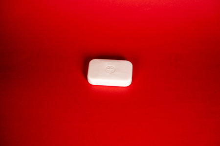 Soap bar in foam with copy space in center isolated on bright red background.