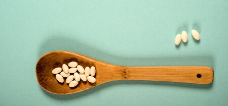 Wooden spoon with a measuring tape on a blue background, diet, healthy lifestyle.の写真素材