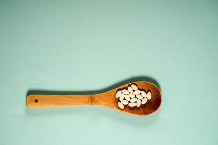Wooden spoon with a measuring tape on a blue background, diet, healthy lifestyle.の写真素材