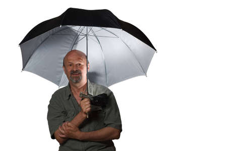 The man holds reflecting umbrella and is shined with external flashの写真素材