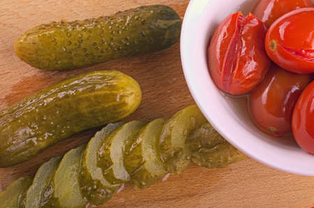 The pickle cut on segments, and marinated tomatoes in a plateの写真素材
