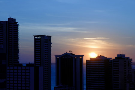Sun down behind the buildings in the city .の写真素材