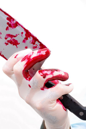 Hand with glove holding a cleaver .
