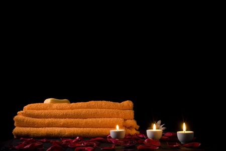 candles and flowers before towel at night .の写真素材