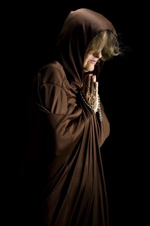 Religious woman praying and holding a rosaryの写真素材