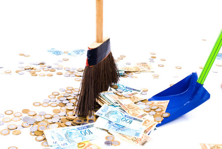 Paper money and Coins on the floor being swept with a broom .の写真素材