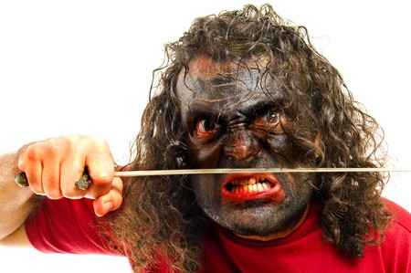 Crazy man with his face painted, holding a swordの写真素材