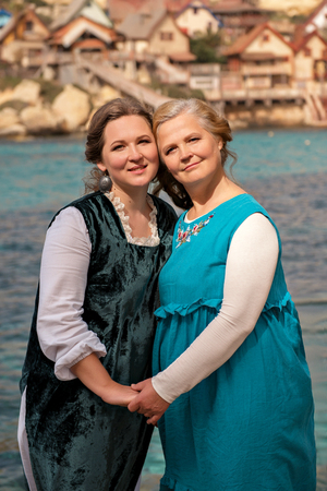 Portrait of two young women in an old fashion house in the background.の写真素材