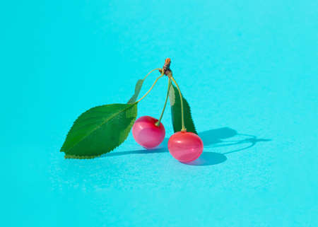 Cherry made of  red balloons on bright blue background. Minimal fruit concept. Summer fun.の写真素材