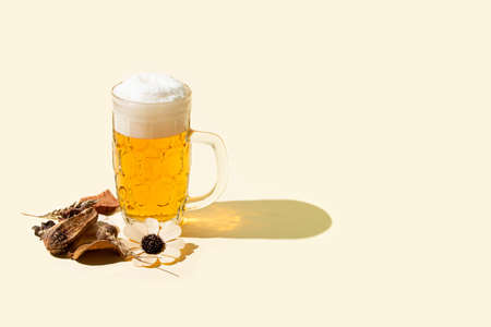 a mug of cold beer with foam on pstel yellow background, pub layoutの写真素材