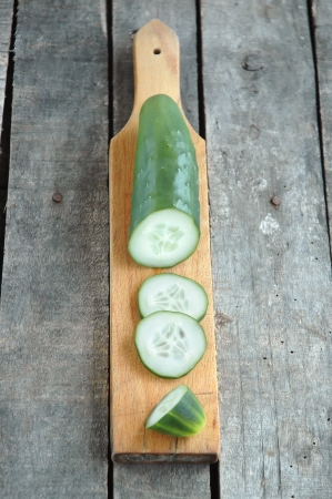 Cut cucumber on wooden cutting boardの写真素材
