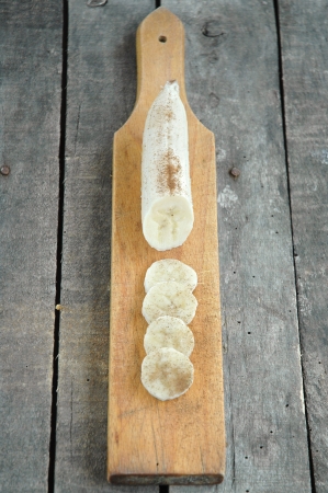 Peeled and sliced banana with cinnamon on cutting board の写真素材