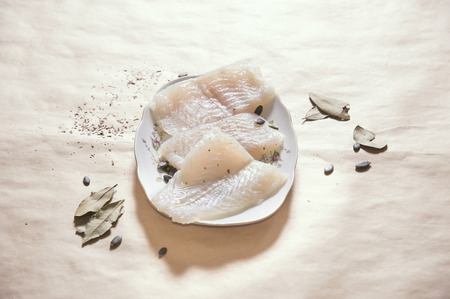Horizontal image of raw pangasius fish with spices on plate, copy spaceの写真素材