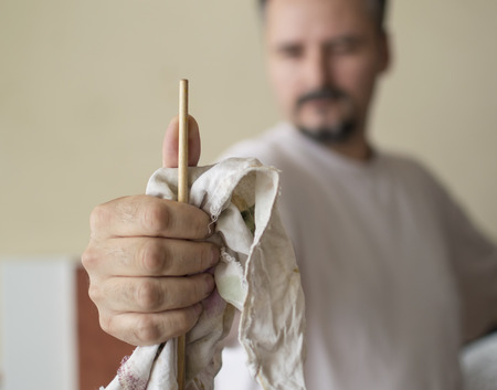 Close up of painters hand measuring proportions with the handle of the brush, thumb methodの写真素材