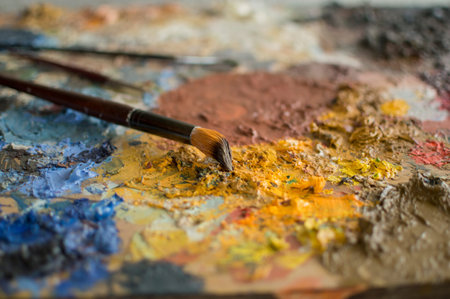 Three brushes on palette with focus on one of them