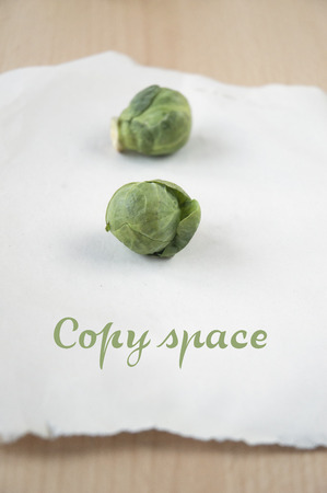 Brussels sprouts on white paper with copy spaceの写真素材