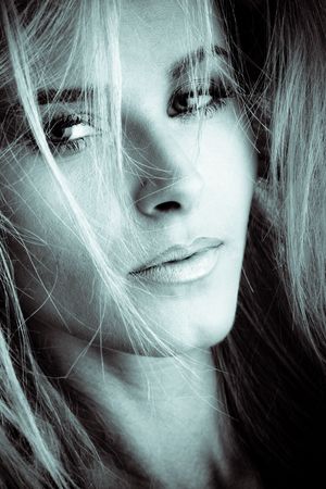 blond woman with hair over face, closeupの写真素材