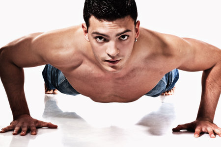 young handsome man working pushups, studio shot