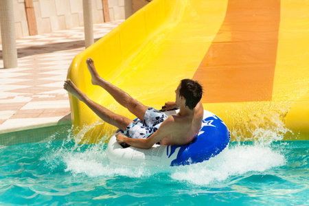 boy having fun in aquapark on a water slider
