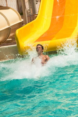 boy having fun in aquapark on a water sliderの写真素材
