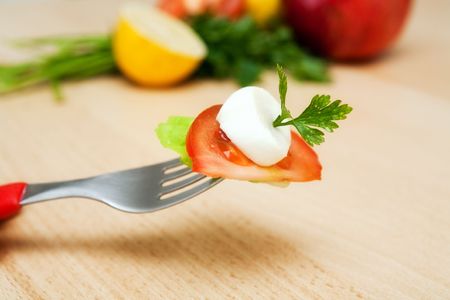 fresh tomato, lettuce and mozzarella cheese on a forkの写真素材