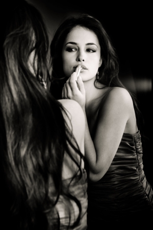 beautiful woman in front of mirror bwの写真素材