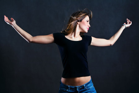 young woman stand with hands wide open, studio shotの写真素材