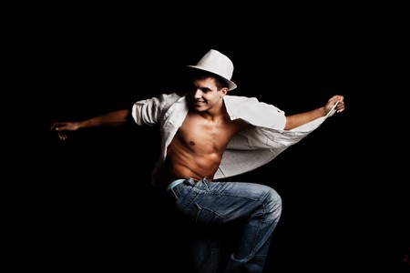 handsome young man in white shirt and hat in motionの写真素材