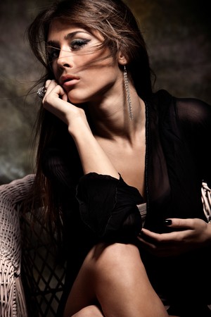 young beautiful brunette woman sit in arm chairの写真素材