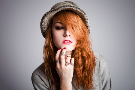 young modern red hair woman with hat, portrait, studio shotの写真素材