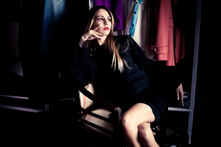 young woman in elegant black dress sit in dressing roomの写真素材