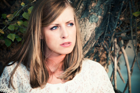 adult pensive woman portrait outdoor shot next to tree