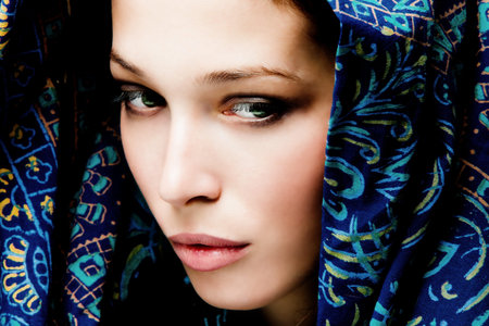 beautiful woman face with oriental scarf around, studio shot