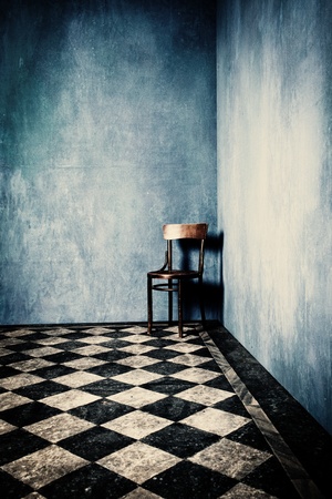 grunge room with blue old walls tiled floor and wooden chair in cornerの写真素材