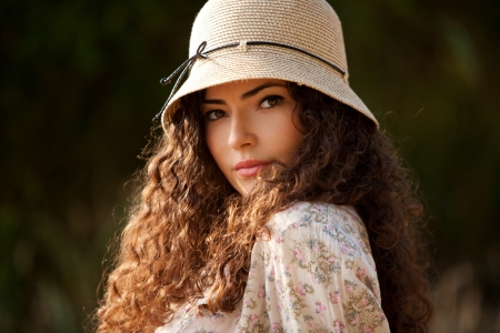 young woman portrait with hat outdoor in park summer day sunsetの写真素材