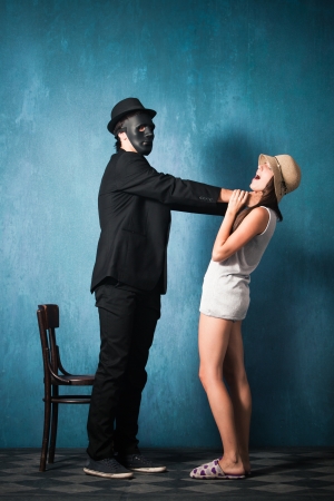 man with black mask strangle  young girl studio shotの写真素材