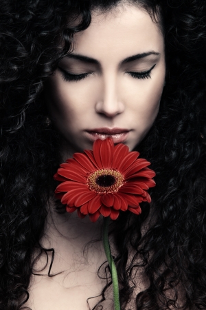 curly hair  young woman beauty portrait with flowerの写真素材