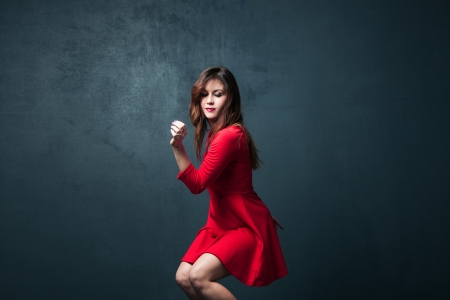 young woman dance in red short dressの写真素材
