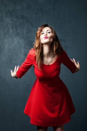 woman in red dress with kiss expression の写真素材