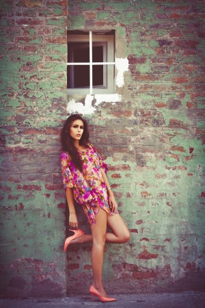 woman in colorful summer dress lean on wall outdoor shot summer dayの写真素材