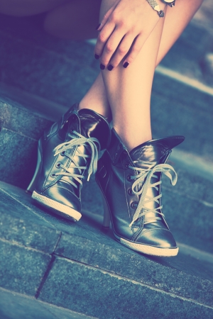 woman legs in  high heel sneakers outdoor shot on stairs retro colorsの写真素材