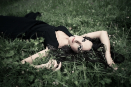 beauitful elegant mature woman lie in grassの写真素材