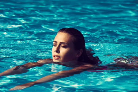 young beautiful  woman swimming in the pool