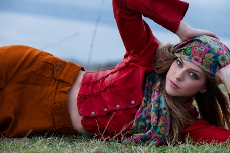 young blonde woman in autumn fashion clothes,  red leather jacket, cashmere scarf and brown skirt outdoor shotの写真素材