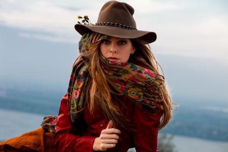 young blond woman in autumn fashion clothes,  red leather jacket, hat, cashmere scarf and brown skirt outdoor shotの写真素材