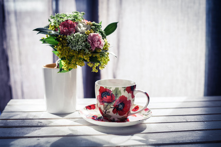 cup of coffee and flowers on white wooden table retro colorsの写真素材
