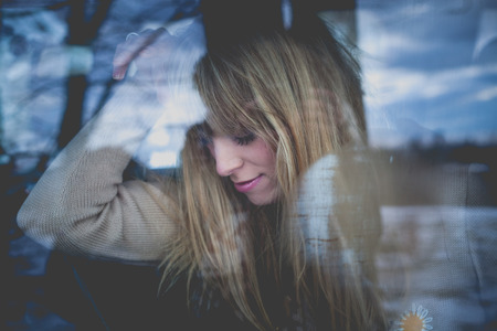 young woman portrait in the car behind the windowの写真素材