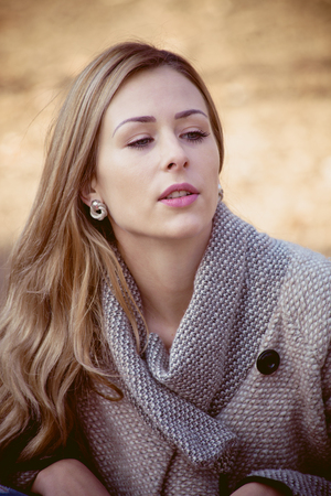 young beautiful woman in coat outdoor portrait, feel warmの写真素材