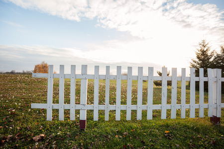 escape from the city, white wooden fence on field with sky in backgroundの写真素材