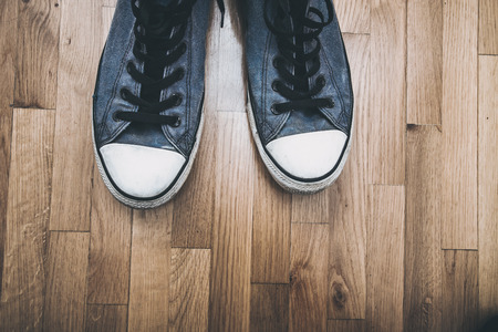 pair of men blue sneakers on parquet view from above closeupの写真素材